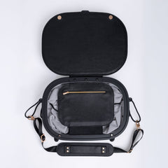 Black leather travel bag with open lid on a white background. Small internal pocket with a zip.