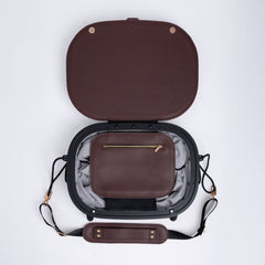 Brown leather travel bag with open lid on a white background. Small internal pocket with a zip. 